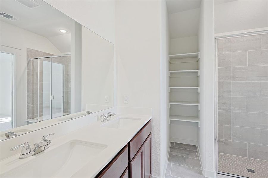 Bathroom with tile patterned flooring, vanity, and a shower with shower door