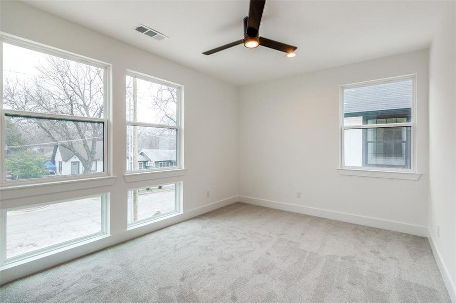 Unfurnished room with light colored carpet and ceiling fan