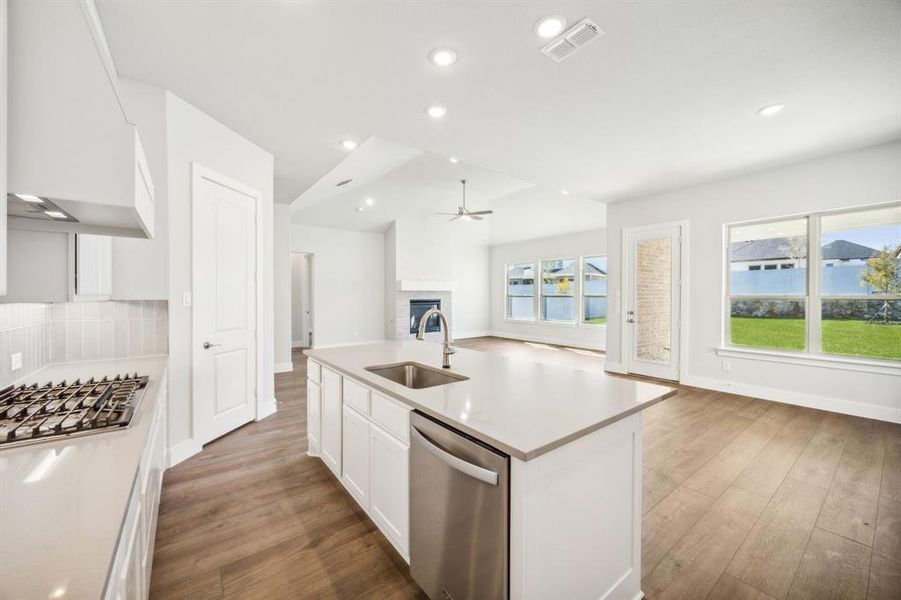 Kitchen with plenty of natural light, sink, an island with sink, and appliances with stainless steel finishes