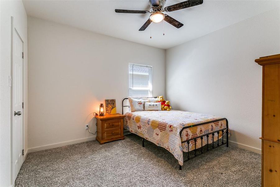 Carpeted bedroom featuring ceiling fan and baseboards Carpeted bedroom featuring ceiling fan and baseboards