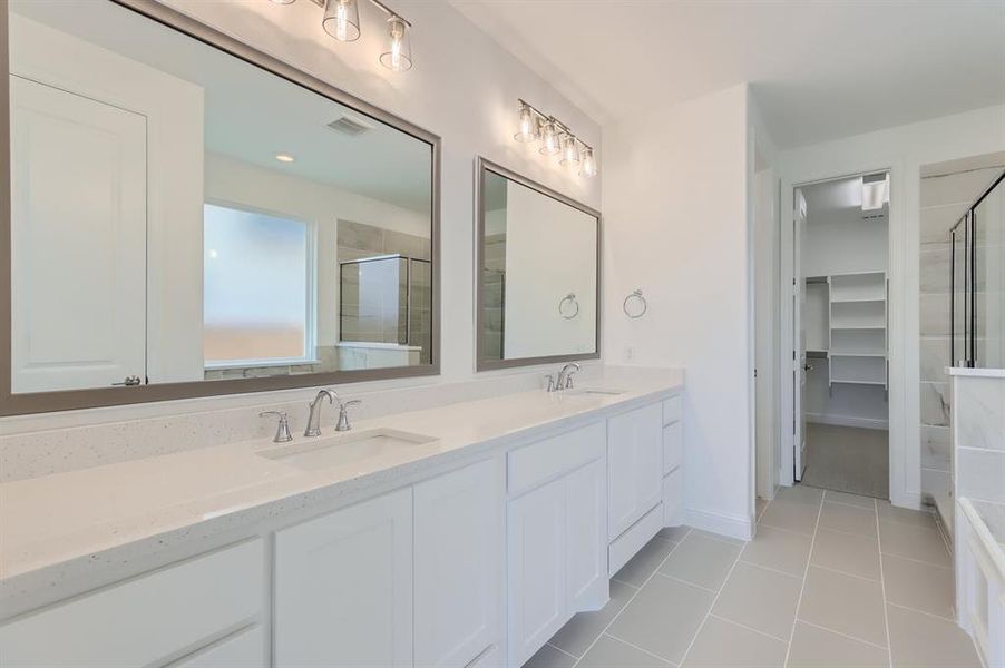 Bathroom featuring dual bowl vanity and tile floors