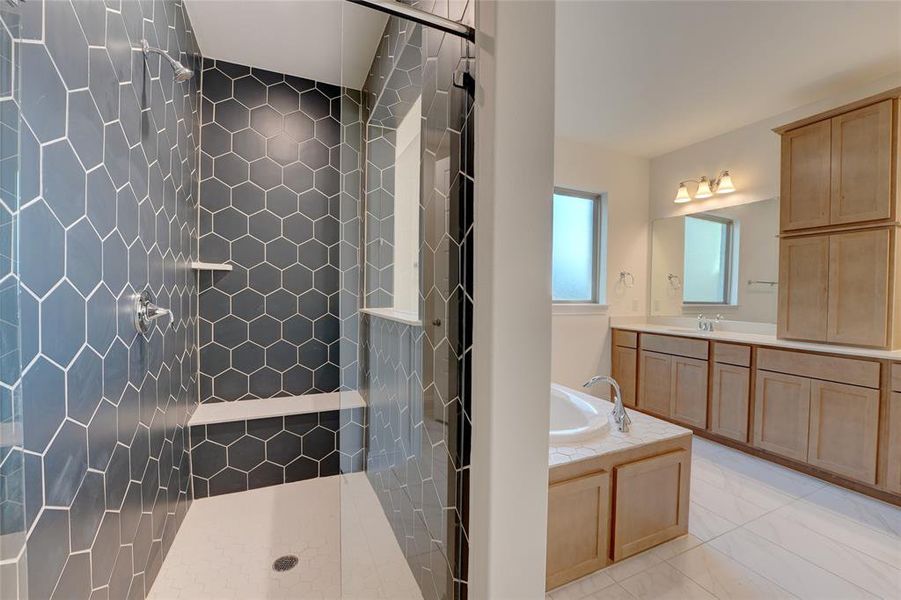 Full bathroom with a bath, vanity, and a tile shower