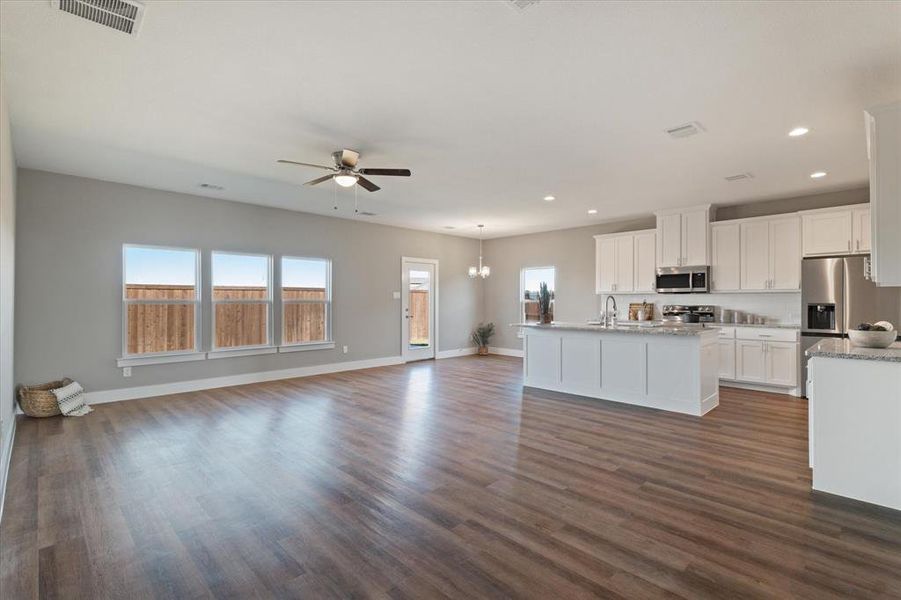 Kitchen with dark hardwood / wood-style flooring, stainless steel appliances, white cabinetry, and sink Kitchen with dark hardwood / wood-style flooring, stainless steel appliances, white cabinetry, and sink