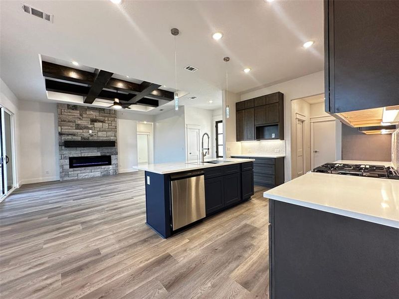 Kitchen featuring a sink, open floor plan, light wood-style floors, dishwasher, and visible vents