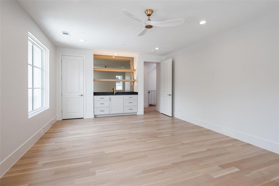 Unfurnished bedroom featuring sink, light wood-type flooring, and ceiling fan