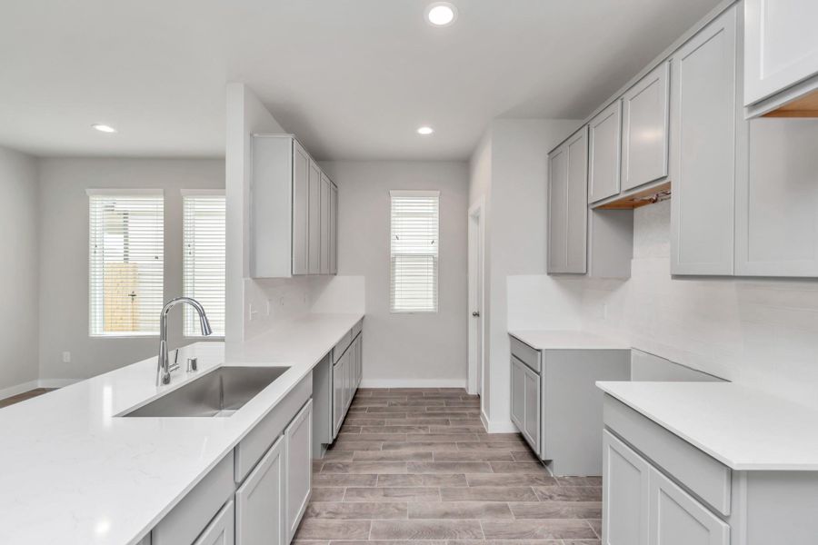 Discover another perspective of this stunning kitchen, generously appointed with an abundance of counter space. Sample photo of completed home with similar floor plan. Actual colors and selections may vary.