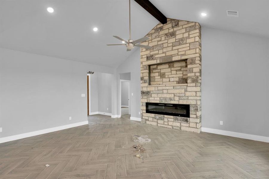 Unfurnished living room with beamed ceiling, a stone fireplace, high vaulted ceiling, ceiling fan, and recessed lighting