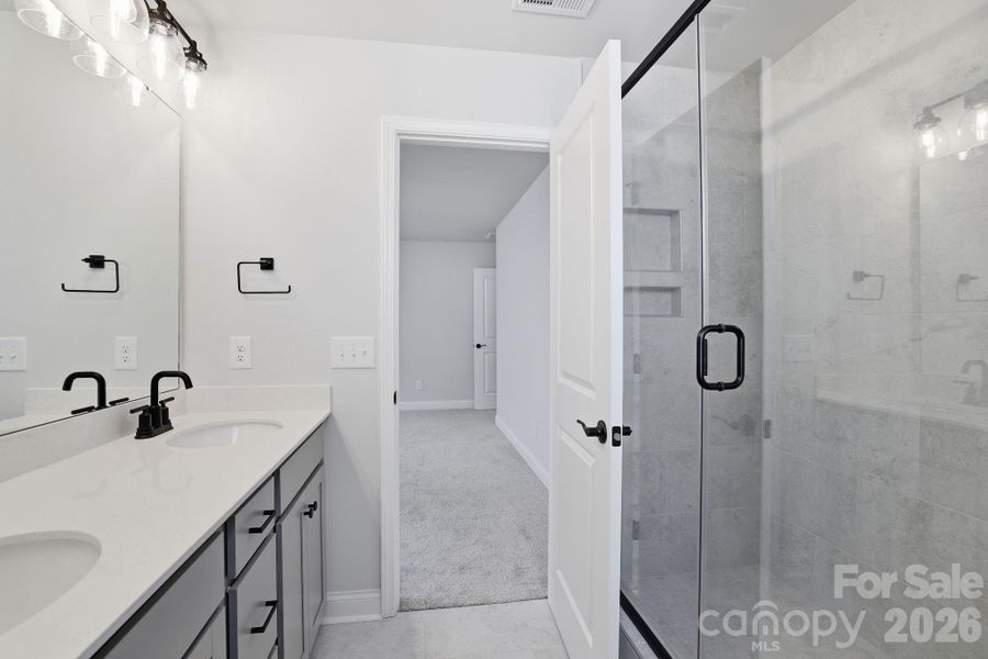 Primary Bath with quartz counters, gray cabinets and tiled shower Primary Bath with quartz counters, gray cabinets and tiled shower