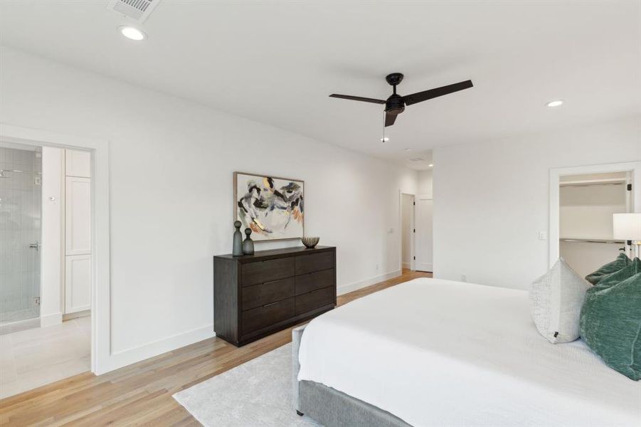 Bedroom with ensuite bathroom, ceiling fan, and light wood-type flooring