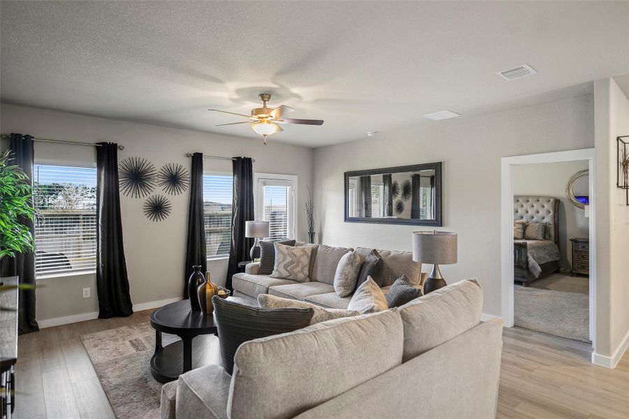 Bright and inviting living room with ample natural light, seamlessly connecting to a comfortable bedroom.
