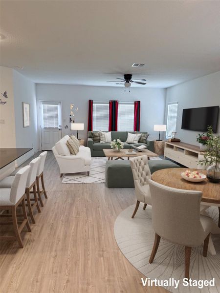 An open-concept living space with light wood flooring provides seamless flow for daily living.