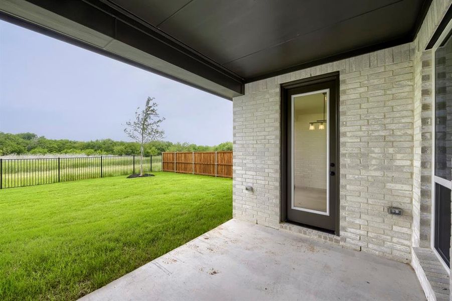 Covered patio featuring a concrete slab and light-toned brick exterior Covered patio featuring a concrete slab and light-toned brick exterior