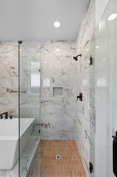 Bathroom featuring a freestanding tub, a shower stall, and tile walls Bathroom featuring a freestanding tub, a shower stall, and tile walls