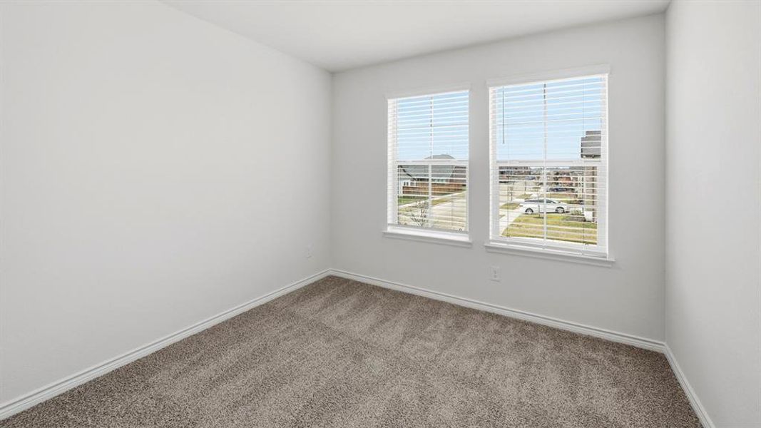 Room with gray carpeting and white walls, featuring two windows with white blinds