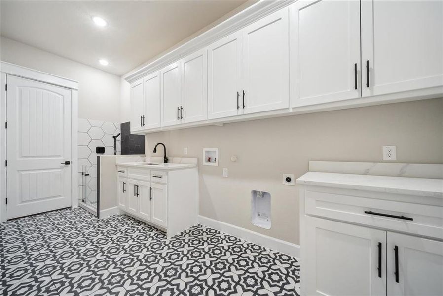 Laundry area with cabinets, electric dryer hookup, sink, and washer hookup