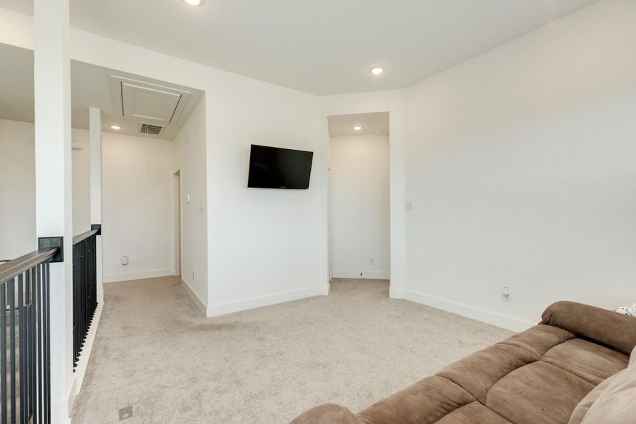 From this perspective, the entrance to the primary suite is visible, and to the left are the secondary bedrooms and laundry room, creating a split floor plan.