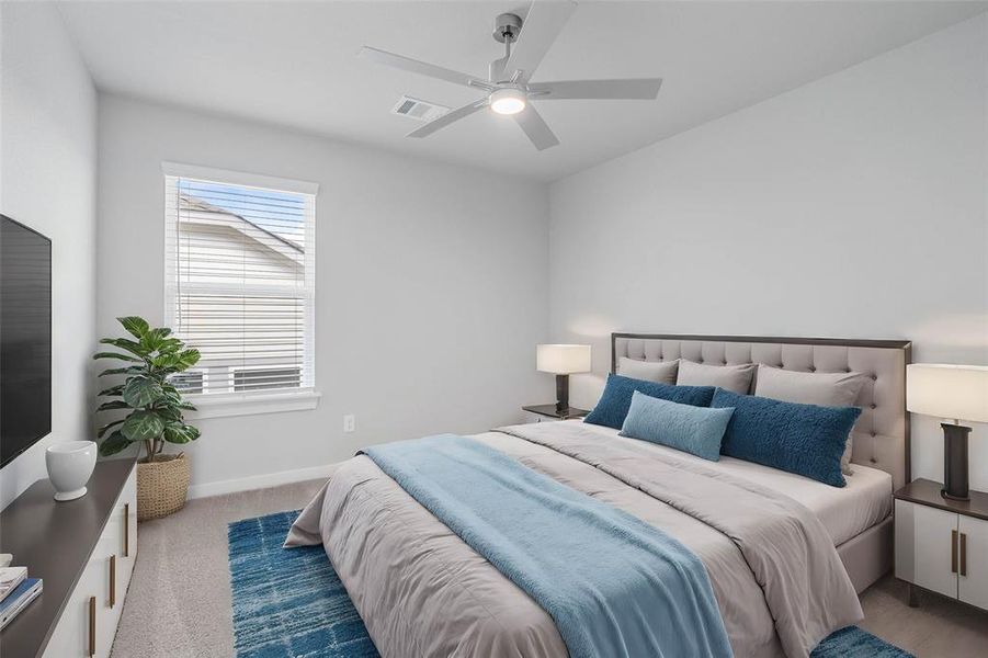 Secondary bedroom features plush carpet, custom paint, ceiling fan and a large window with privacy blinds.