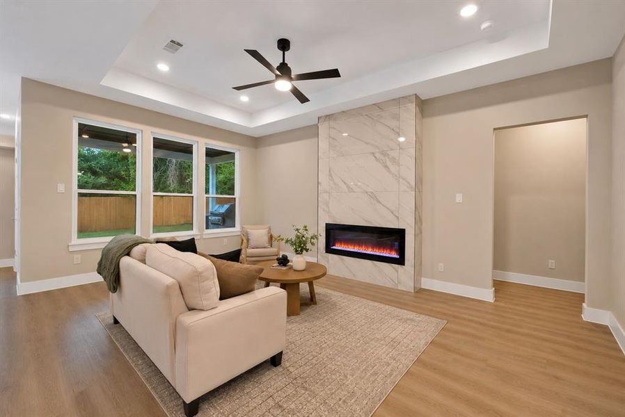 Open living area featuring a tray ceiling with recessed lighting and a ceiling fan Open living area featuring a tray ceiling with recessed lighting and a ceiling fan