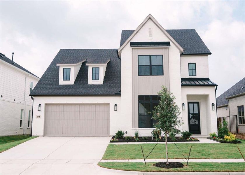 Modern farmhouse style home featuring a front yard and a garage