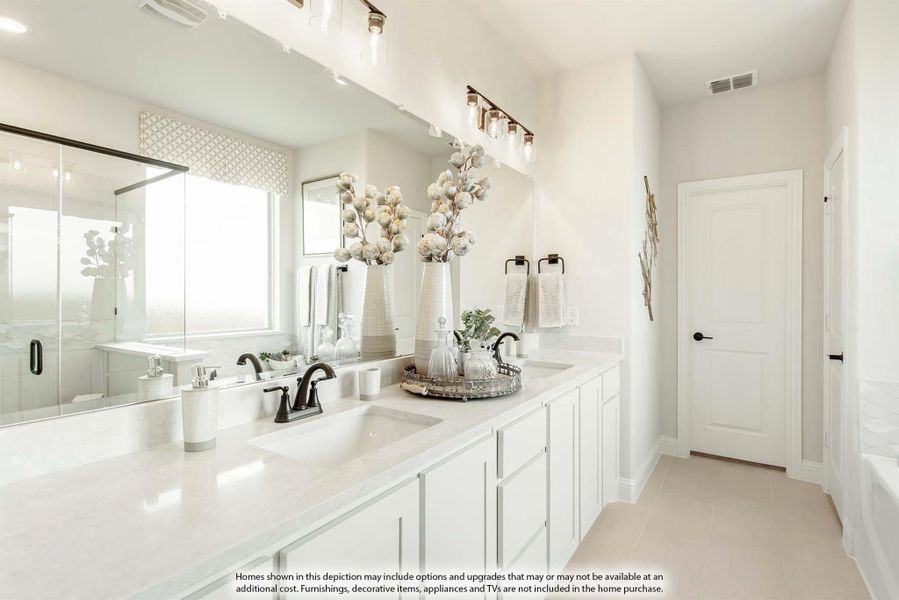 Bathroom with double sink vanity, white cabinets, large mirror, and glass shower enclosure