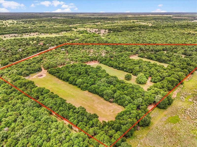 Expansive acreage featuring a mix of cleared pastures and mature tree lines