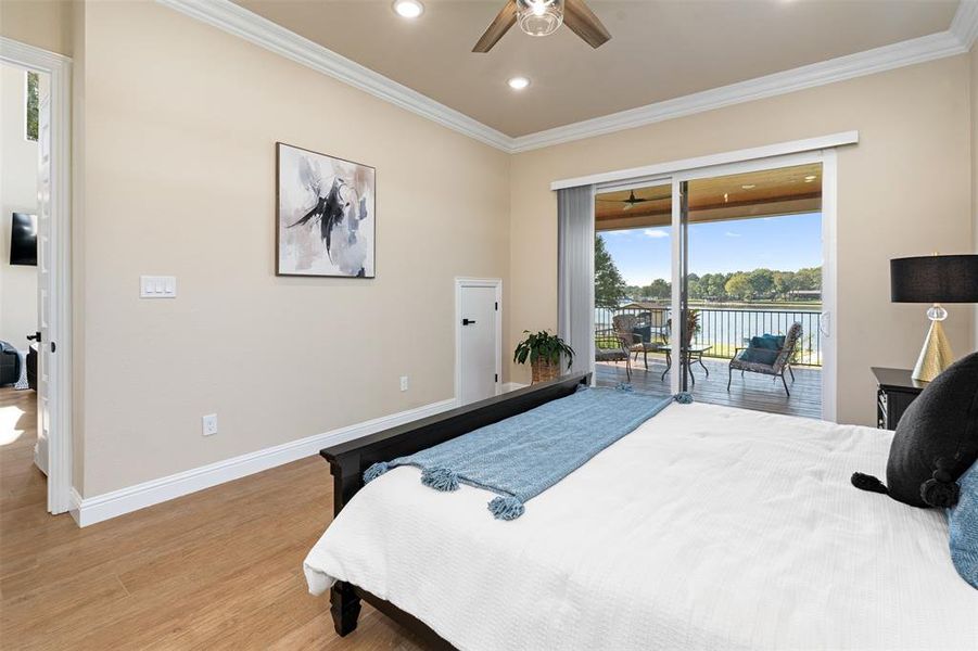 Bedroom featuring access to outside, light hardwood / wood-style floors, multiple windows, and ceiling fan