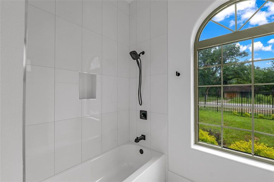 Bathroom 4 showcases arched windows and a tub/shower combo with handheld shower Bathroom 4 showcases arched windows and a tub/shower combo with handheld shower