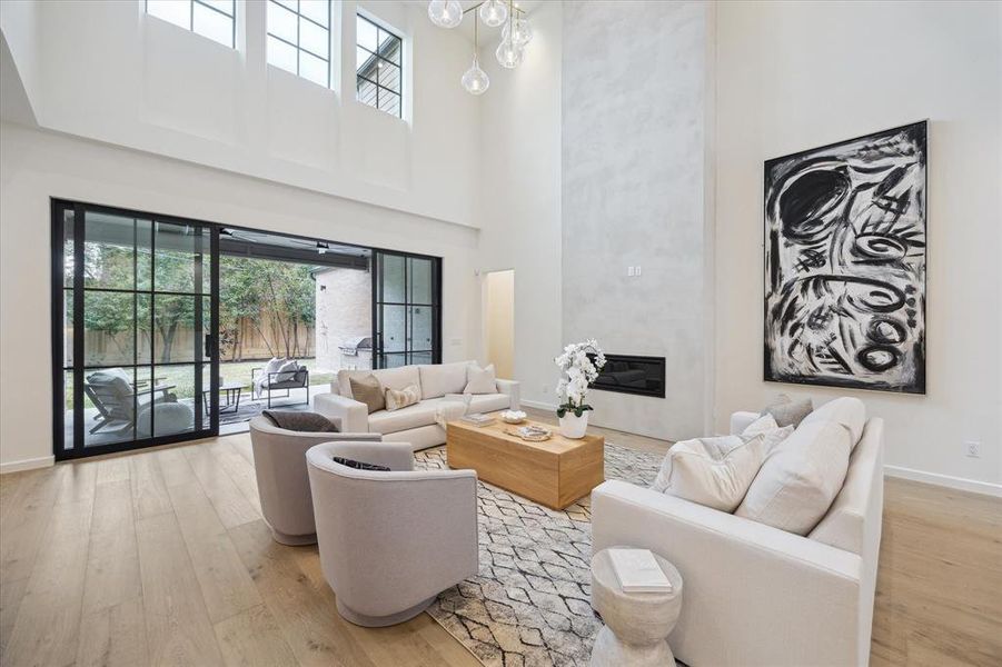 This bright and open living room features a contemporary fireplace and offers a view of the gameroom above, adding character and dimension to the space.