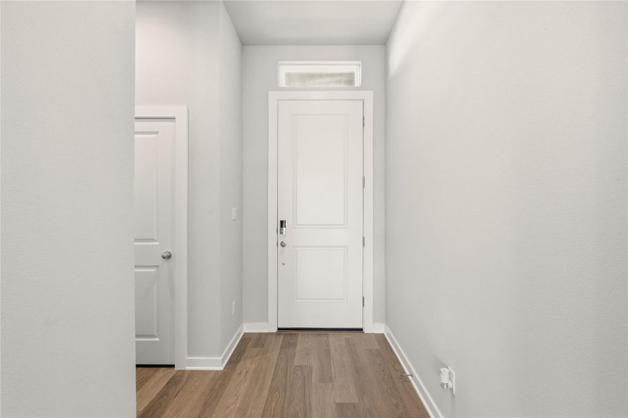 Doorway featuring wood finished floors and baseboards Doorway featuring wood finished floors and baseboards
