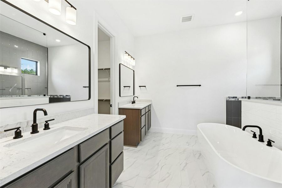 Bathroom with a soaking tub, two vanities, tiled shower, recessed lighting, and light marble finish floors
