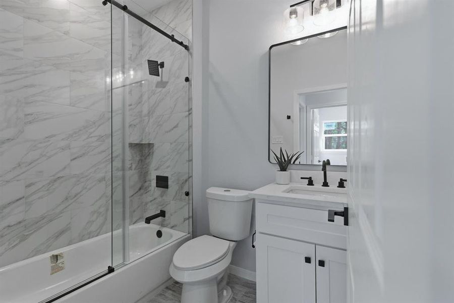 Bathroom featuring vanity and shower / bath combination with glass door Bathroom featuring vanity and shower / bath combination with glass door