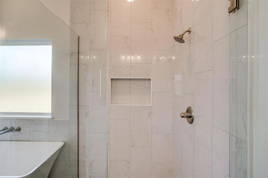 Bathroom with tile walls, sink, plus walk in shower, and plenty of natural light