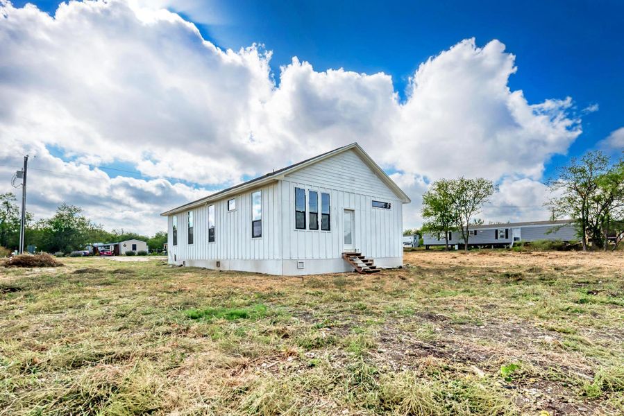 An asymmetric roofline and vertical siding define this modern cottage set on an open lot.