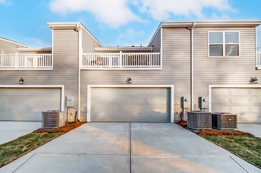 Back exterior with 2-car garage and balcony