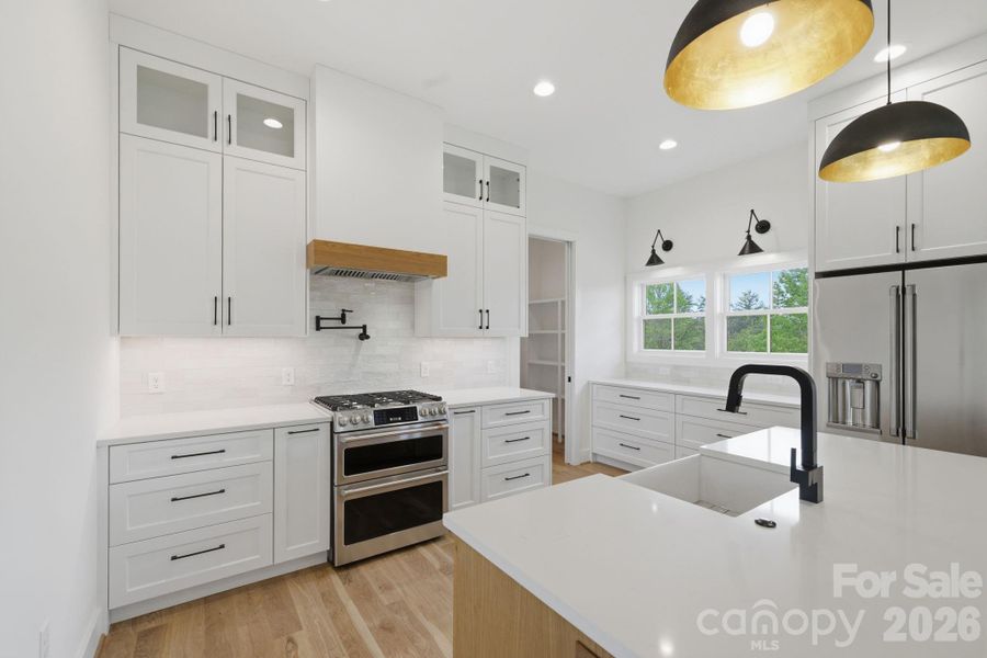 Chef's kitchen feat. double oven, gas range, & pot-filler