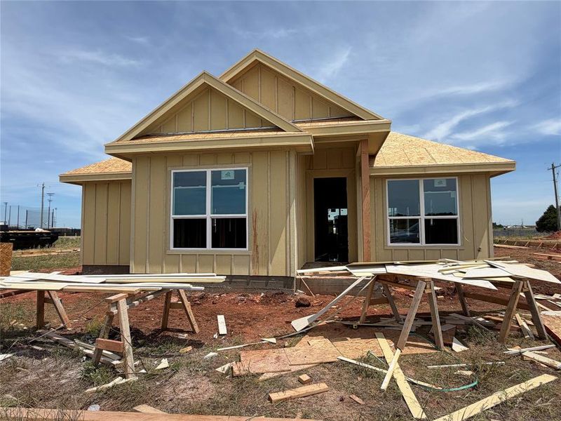Exterior featuring board and batten siding, multiple gables, and uninstalled shingle roofing