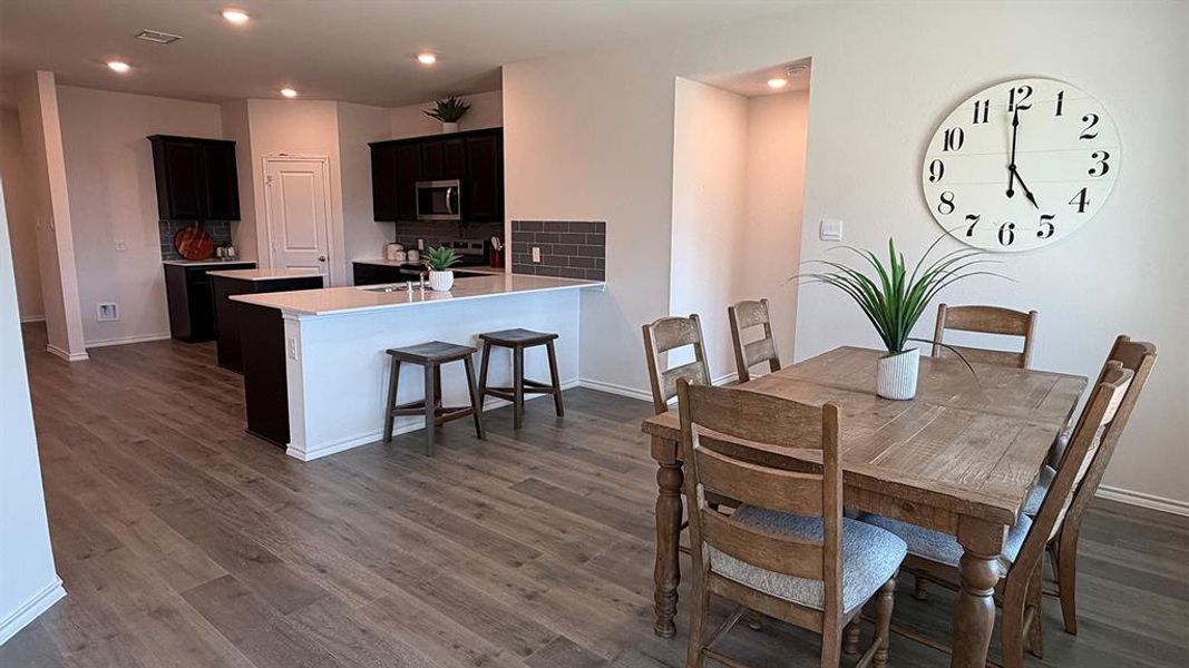 Dining room featuring dark wood-style flooring and recessed lighting