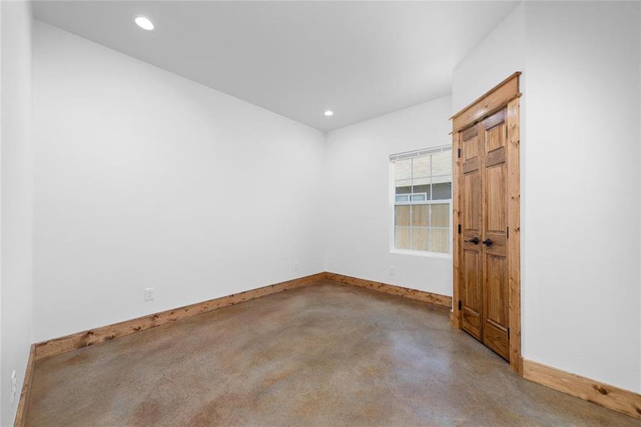Empty room featuring baseboards, recessed lighting, and finished concrete floors Empty room featuring baseboards, recessed lighting, and finished concrete floors