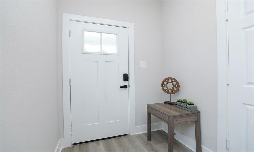 Beautiful hardwood front door with foyer.