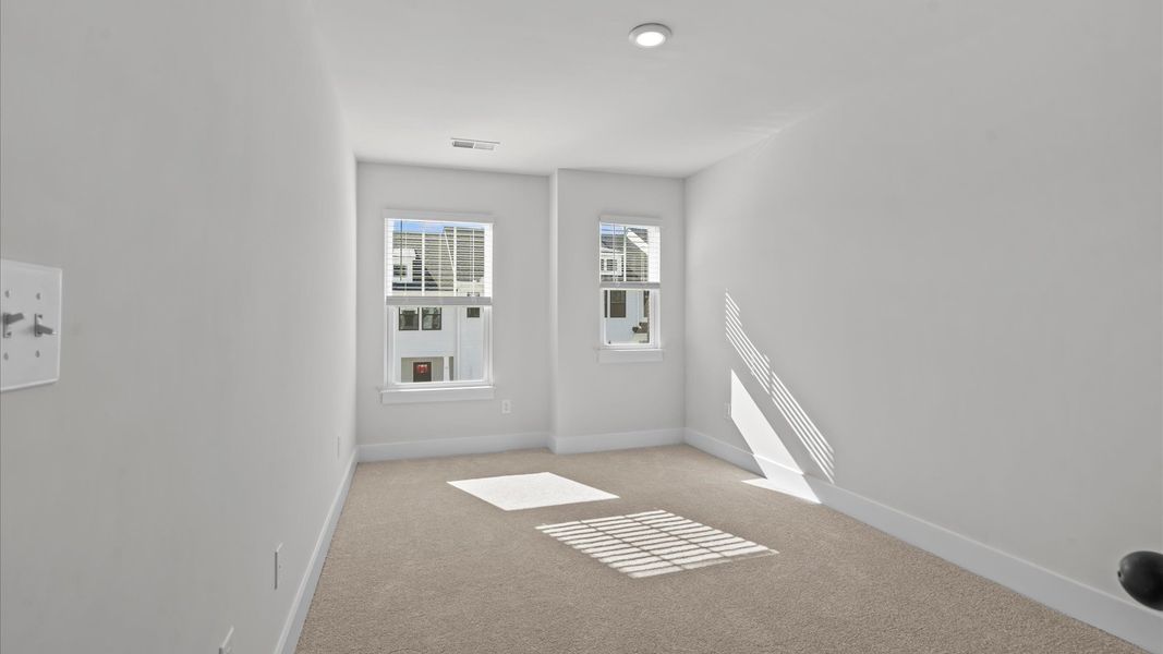 Tasteful bedroom with plush carpet, a walk-in closet, and large windows for abundant natural light in Simpsonville, SC