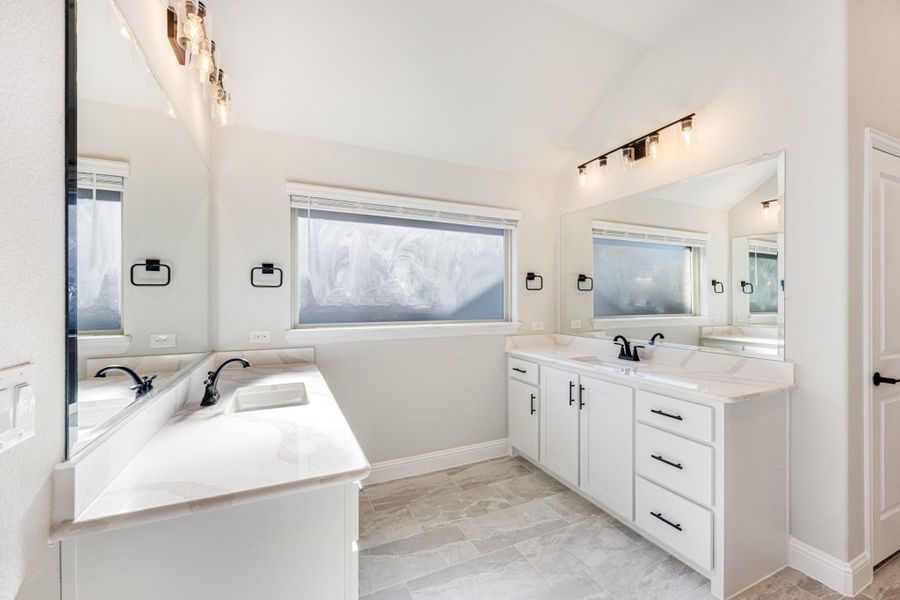 Bathroom with dual vanities, white cabinets, quartz countertops, and tile floors Bathroom with dual vanities, white cabinets, quartz countertops, and tile floors