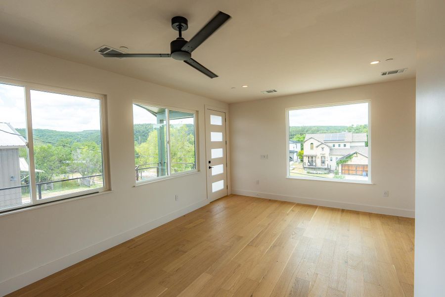 Bright hardwood floors and a modern ceiling fan complement the abundant natural light from numerous windows in this airy room. Connects to balcony. Bright hardwood floors and a modern ceiling fan complement the abundant natural light from numerous windows in this airy room. Connects to balcony.
