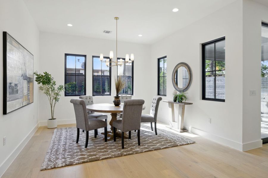Dining space featuring light wood-type flooring, a chandelier, baseboards, and recessed lighting