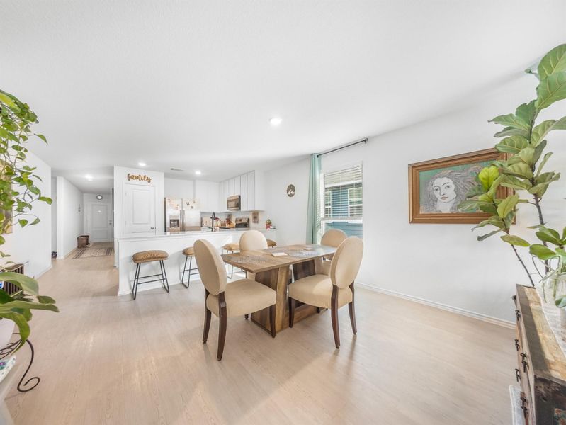 Dining area with light wood-style flooring and recessed lighting
