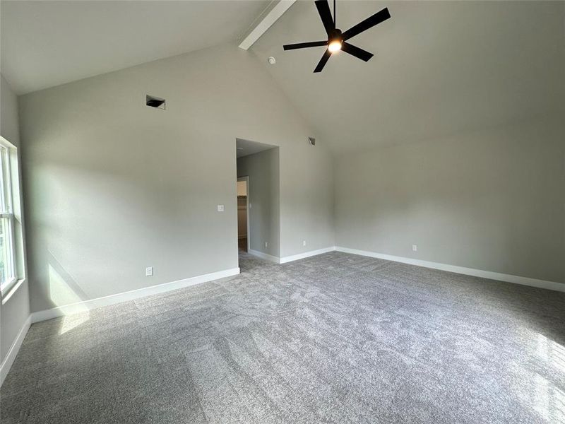 Primary Bedroom with light colored carpet, ceiling fan, high vaulted ceiling, and beamed ceiling