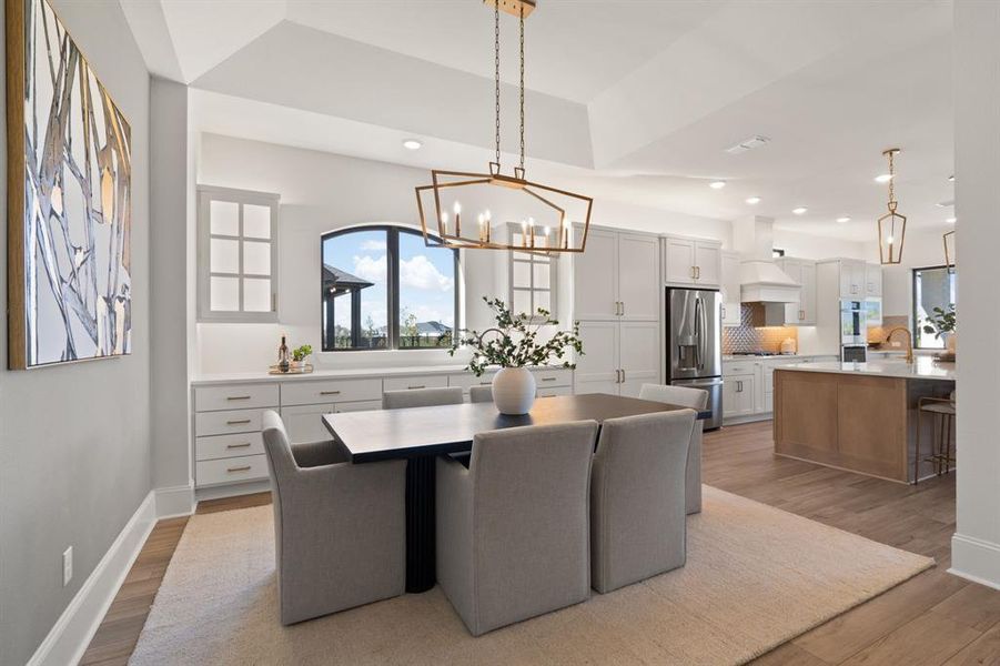 Gold hardware on cabinetry with gold fixture over table