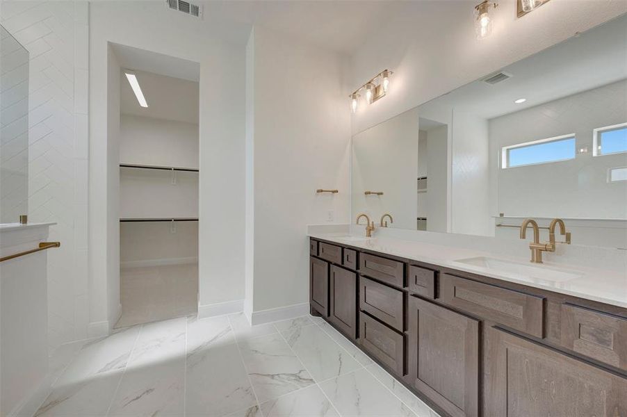 Dual vanity with quartz countertops, undermount sinks, and brass-finish fixtures Dual vanity with quartz countertops, undermount sinks, and brass-finish fixtures