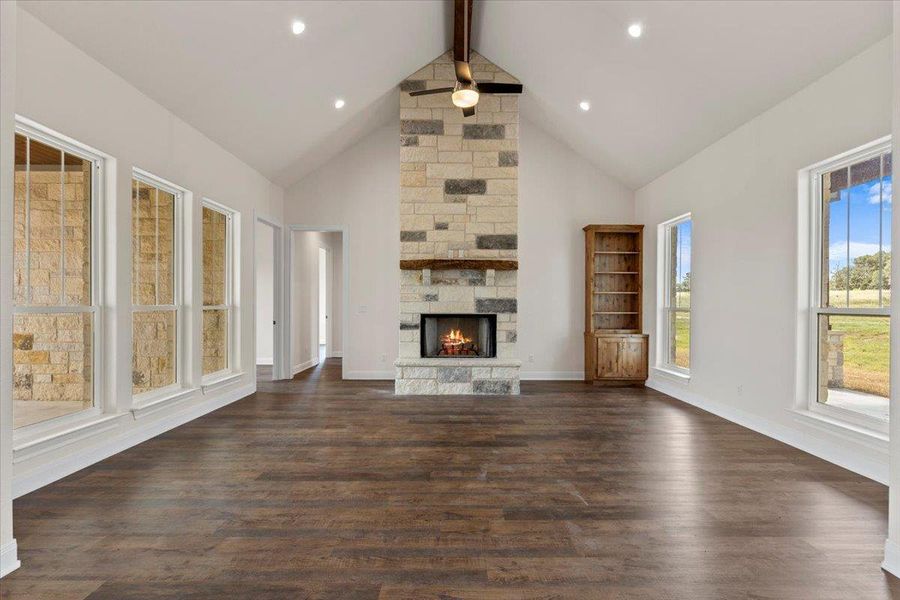 Unfurnished living room with high vaulted ceiling, beamed ceiling, a fireplace, dark wood-style flooring, and recessed lighting