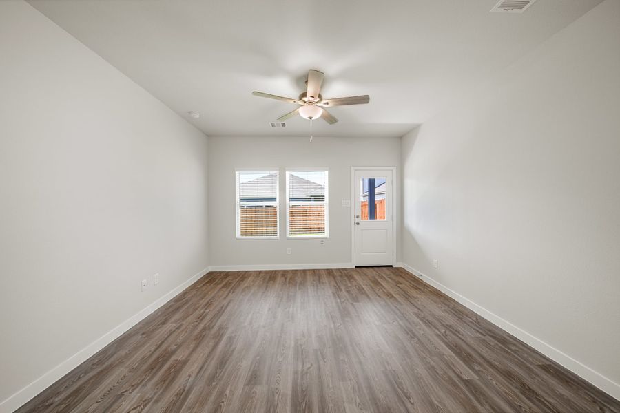 A room with a ceiling fan and a wood floor.