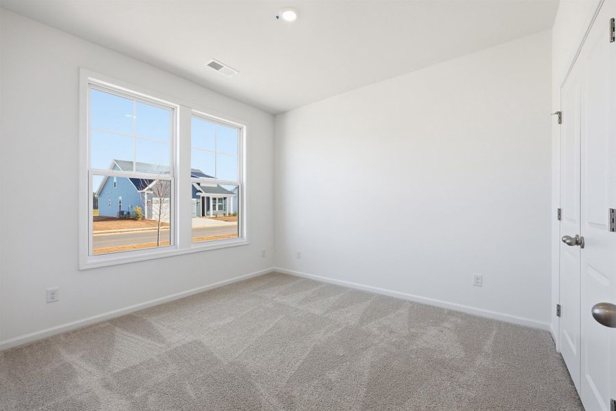 Unfurnished bedroom with light carpet and baseboards Unfurnished bedroom with light carpet and baseboards
